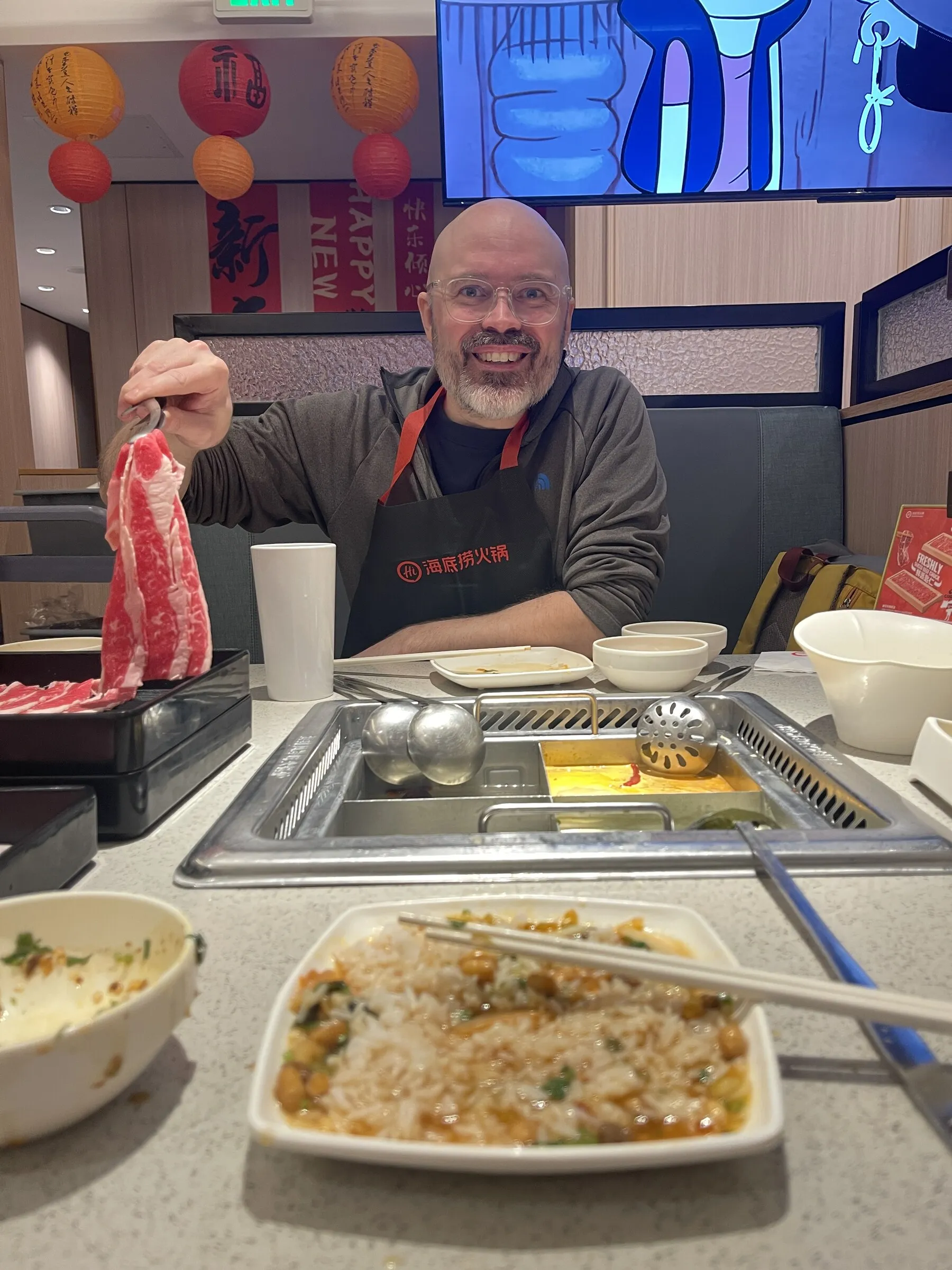 Jesse enthusiastically holding meat above a hot pot